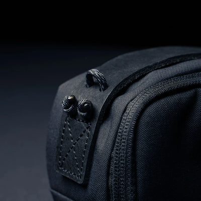 Wotancraft black canvas pouch side tab with paracord loops, close-up