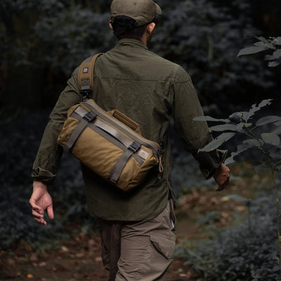 Man walking in a forest wearing the Wotancraft Easy Rider khaki bag