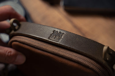 Wotancraft pouch embossed logo on the leather top strap, close-up