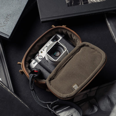 Wotancraft brown leather pouch open with a silver Fujifilm X100 inside