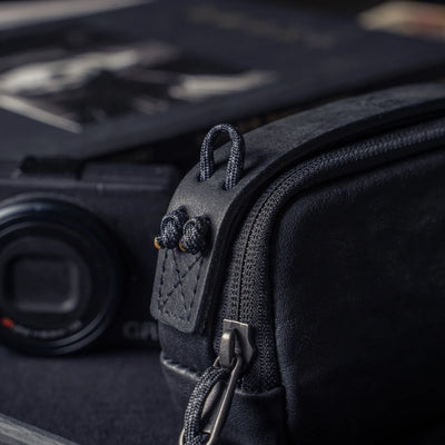 Wotancraft black leather pouch paracord loops close-up with a Ricoh GR behind