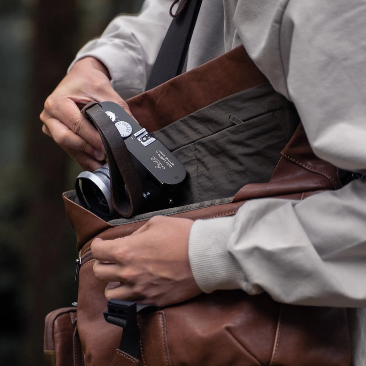 Photographer taking a Leica camera out of the Wotancraft Pilot brown leather bag