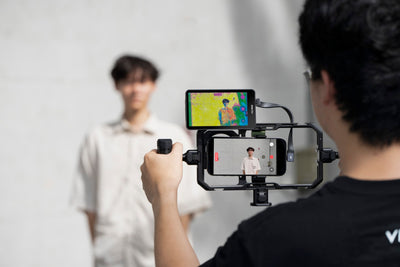 Videographer filming with an iPhone rig and the Viltrox DC-T1 monitor on top