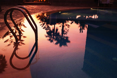 Swimming pool at sunset with palm tree reflections, sample from the Voigtlander Nokton Classic 35mm