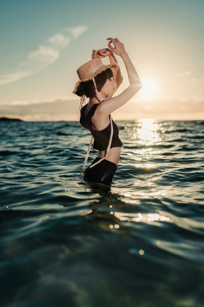 Woman in a straw hat standing in the sea at sunset, sample from the Voigtlander Nokton 40mm f/1.2