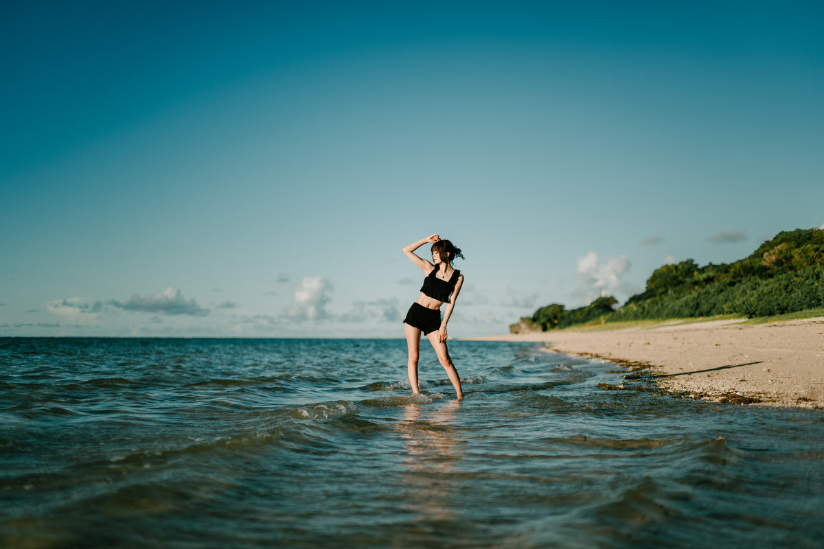Woman standing in shallow sea water on a beach, sample from the Voigtlander Nokton 40mm f/1.2