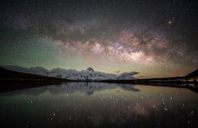 Milky Way over snowy mountains reflected in a lake, astro sample from the Viltrox 16mm f/1.8