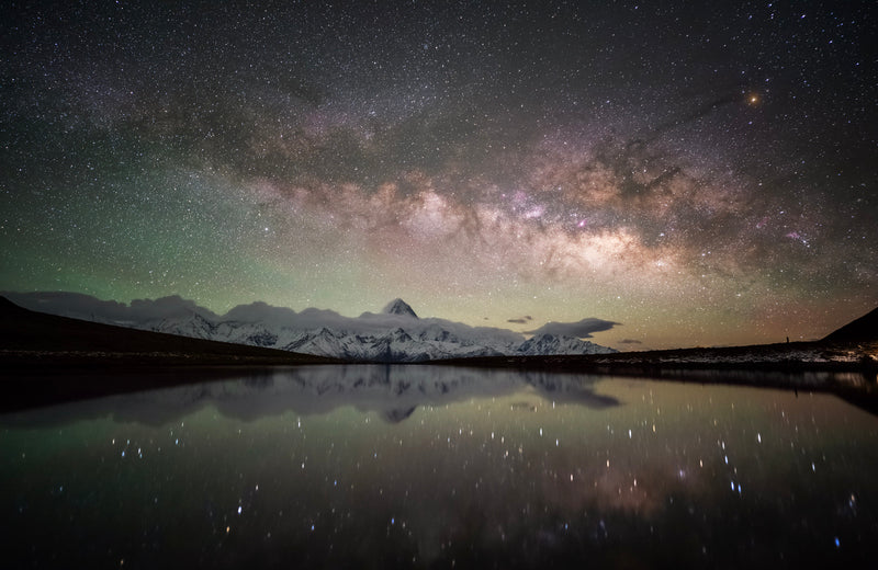 Milky Way over snowy mountains reflected in a lake, astro sample from the Viltrox 16mm f/1.8