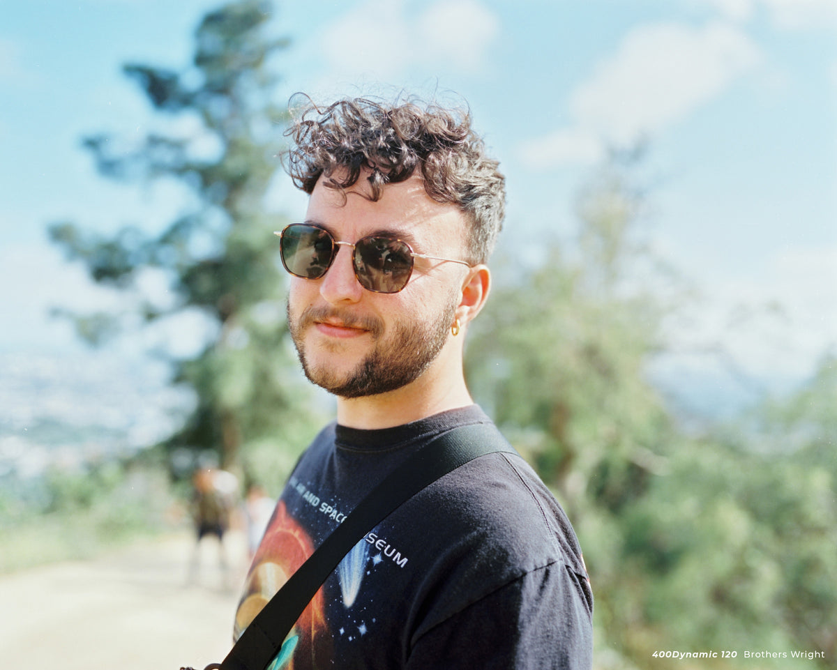 Smiling man with curly hair and sunglasses, sample shot on CineStill 400D