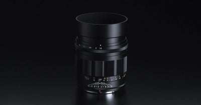 Voigtlander Nokton 75mm f/1.5 Z lens with hood on a dark background