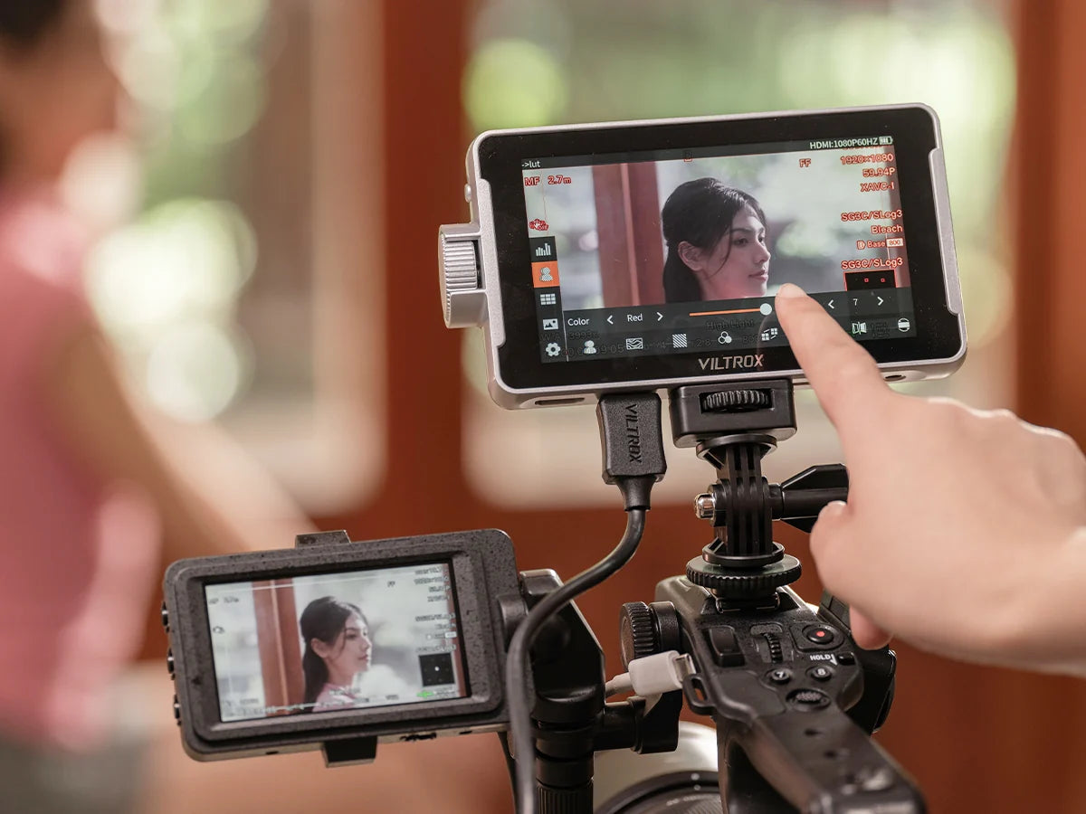 Viltrox DC-V1 monitor mounted on a cinema camera rig, touchscreen in use