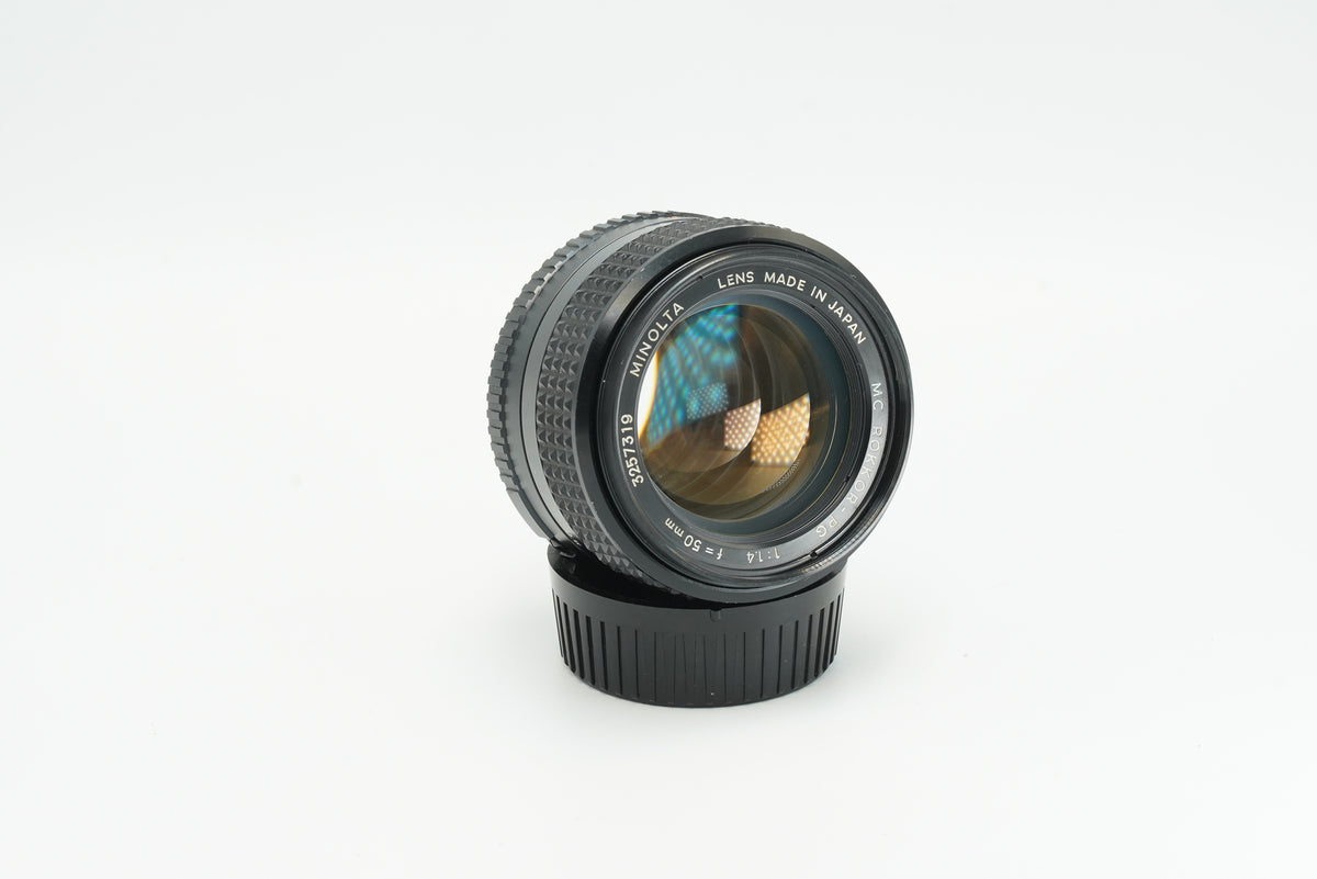 Minolta MC Rokkor-PG 50mm f/1.4 lens, front three-quarter view with rear cap