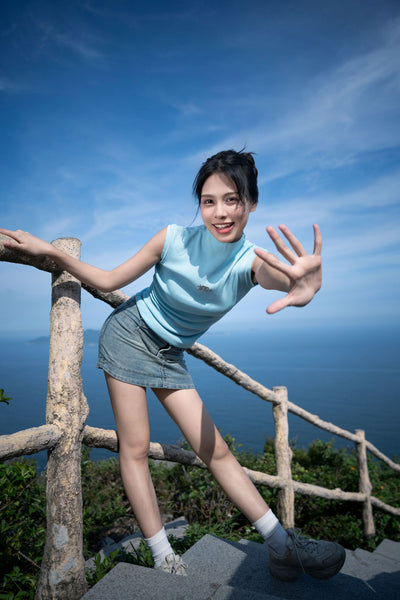 Woman on a hilltop with sea and blue sky, sample from the Viltrox Air AF 15mm f/1.7