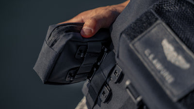 Hand holding a Wotancraft Armor pocket clipped to a bag strap