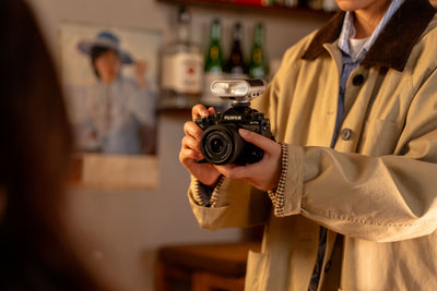 Woman photographing with a Fujifilm camera and the Viltrox Vintage Z1+ flash