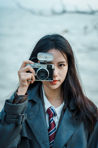 Woman taking a photo with a compact camera and the Viltrox Vintage Z1 flash