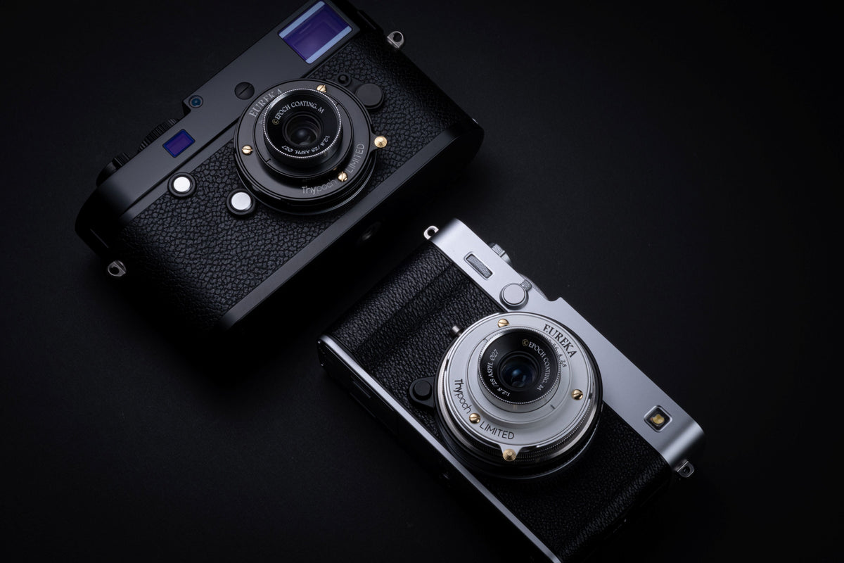 Thypoch Eureka 28mm f/2.8 pancake lenses on a black Leica M and a silver Fujifilm camera