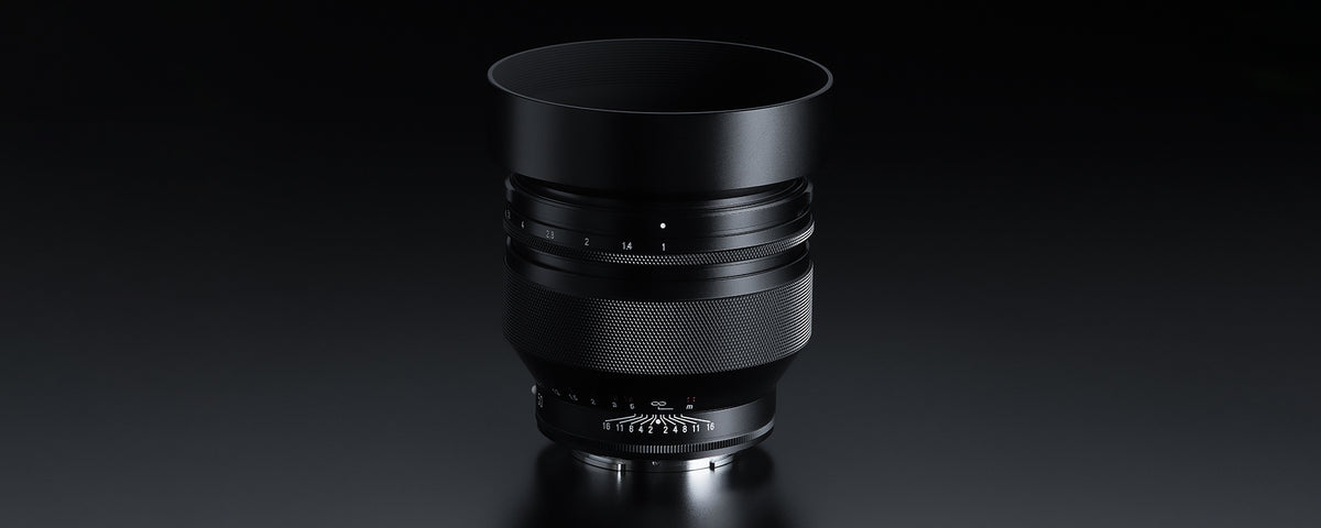 Voigtlander Nokton 50mm f/1.0 E lens with hood on a dark background