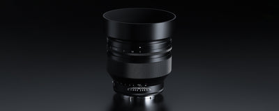 Voigtlander Nokton 50mm f/1.0 E lens with hood on a dark background