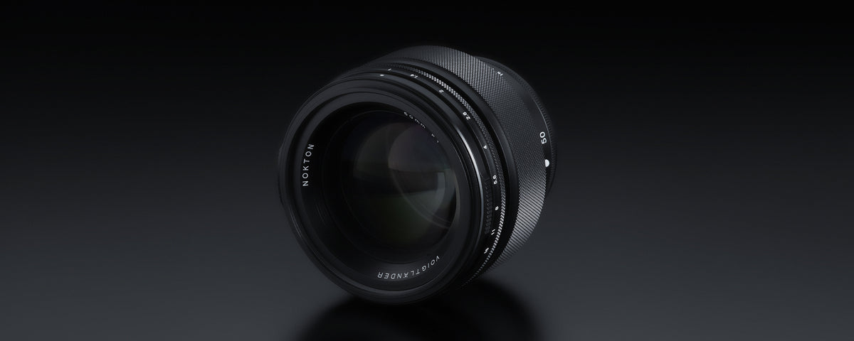 Voigtlander Nokton 50mm f/1.0, angled view of the front element on black