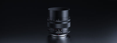Voigtlander Nokton 50mm f/1.2 Fuji X lens with hood on a dark background