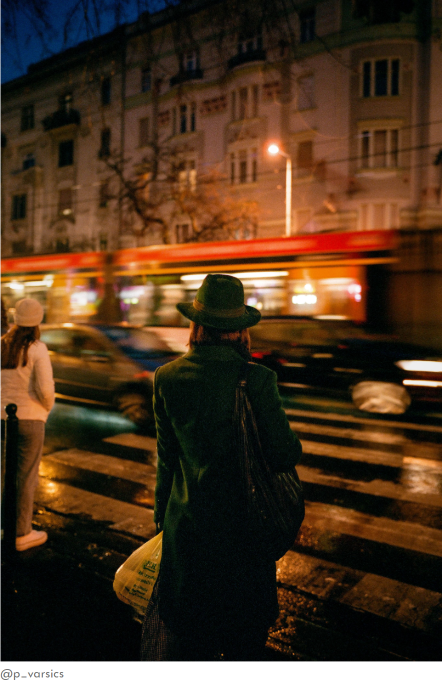 Woman in a hat at a night crossing with a passing tram, Thypoch Simera 28mm sample