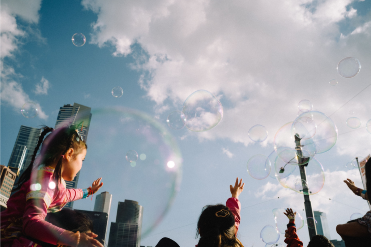 Girl reaching for soap bubbles under a city skyline, sample from the Thypoch Simera 28mm