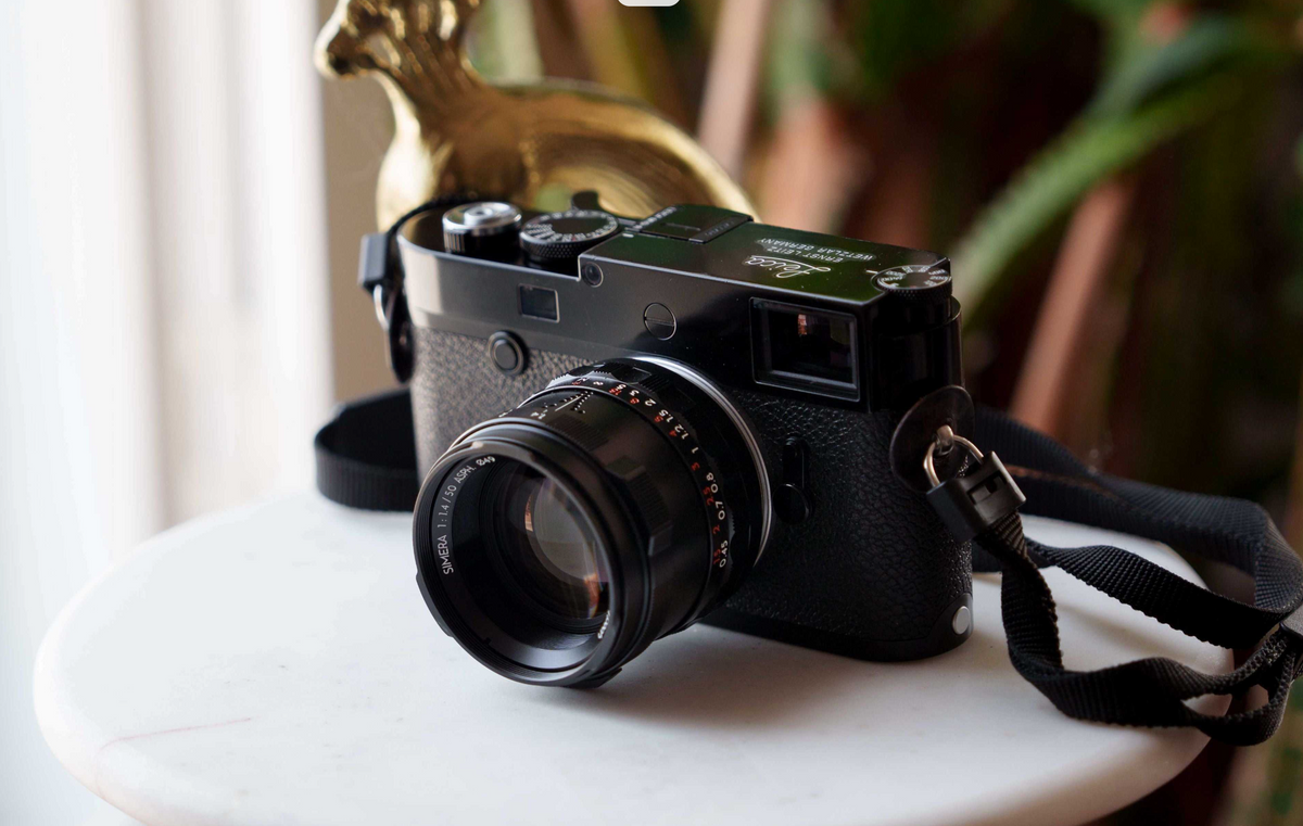 Black Leica M camera with the Thypoch Simera 50mm f/1.4 on a marble table