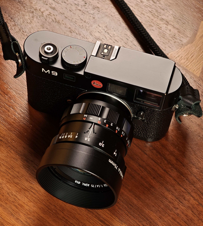 Thypoch Simera 75mm f/1.4 black lens with hood on a Leica M9 camera