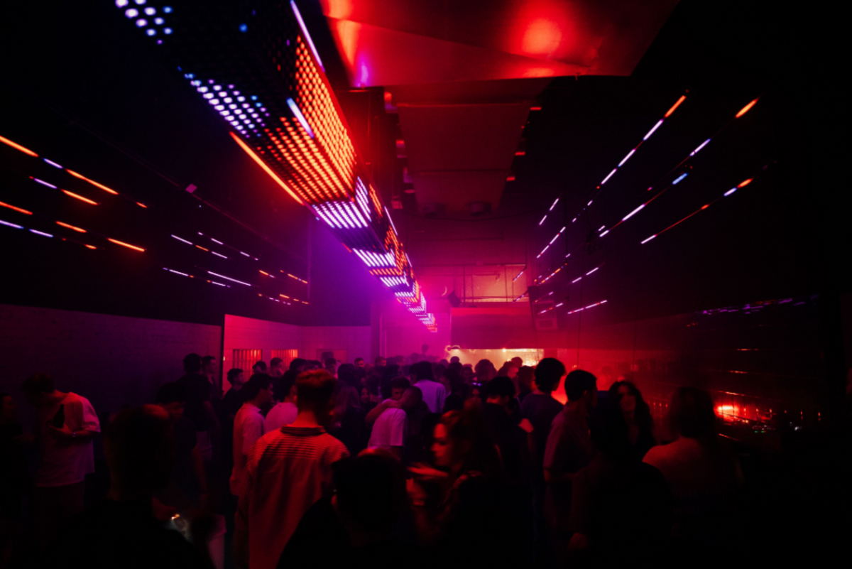 Crowded nightclub with red and purple lights, low-light sample from the Thypoch Simera 21mm f/1.4