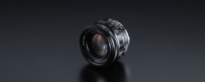 Voigtlander Nokton 40mm f/1.2 Leica M lens on black, angled view