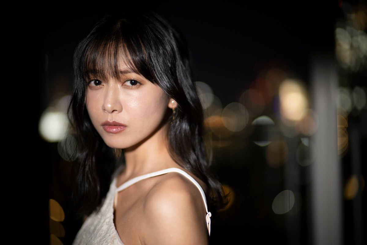 Portrait of a woman with city light bokeh at night, sample from the Voigtlander Nokton 50mm f/1.0
