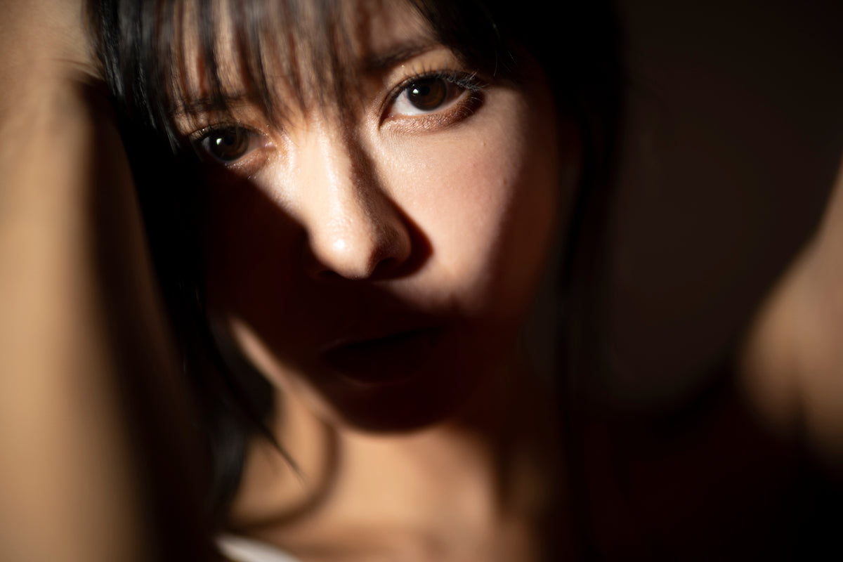 Close-up portrait of a woman in dramatic shadow, sample photo from the Voigtlander Nokton 50mm f/1.0