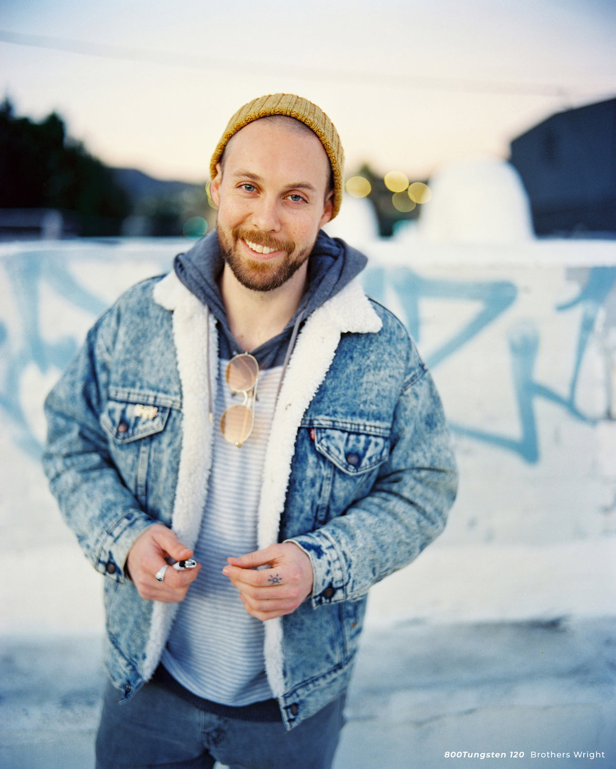 Smiling man in a denim jacket at dusk, sample shot on CineStill 800T