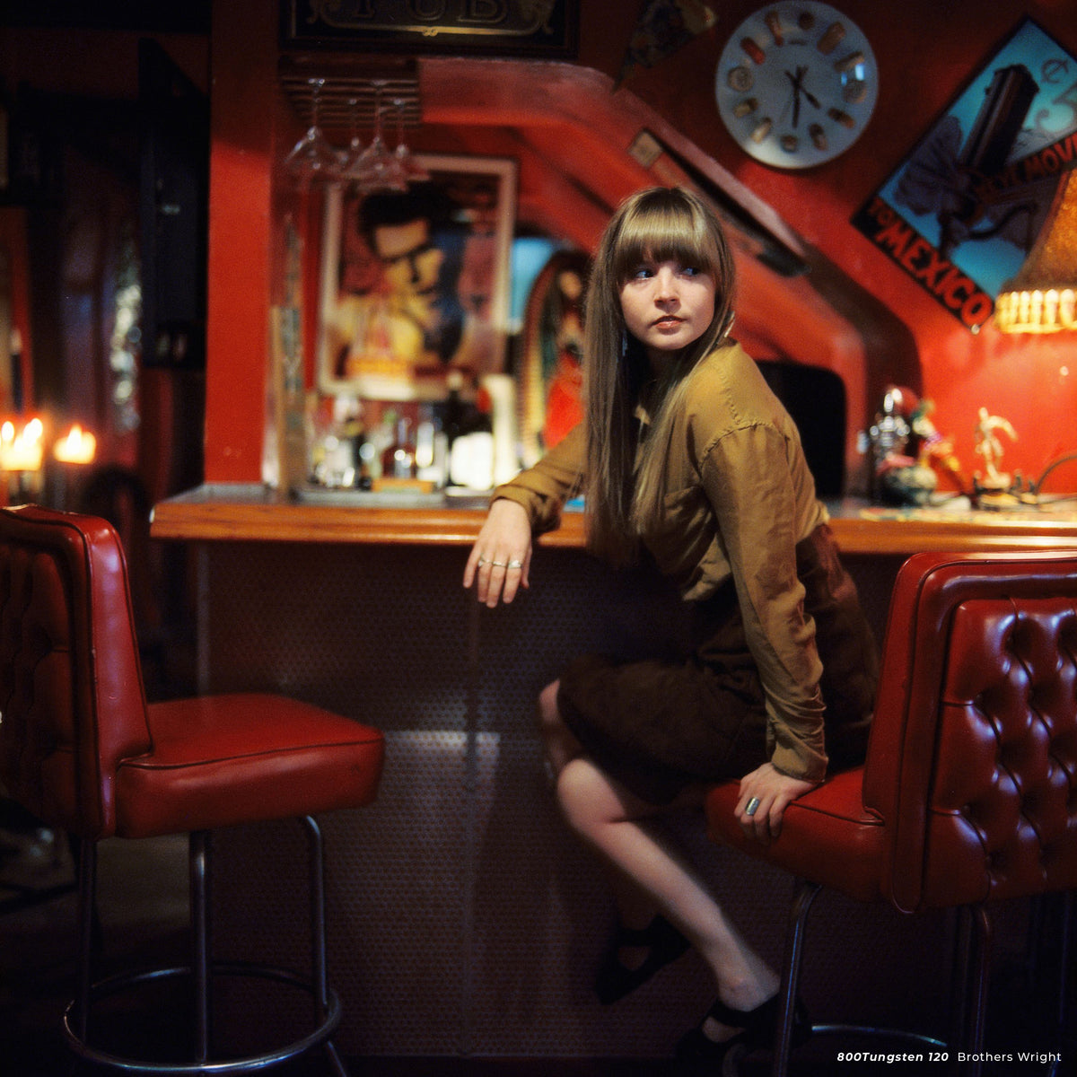 Woman sitting at a red diner bar, sample shot on CineStill 800T