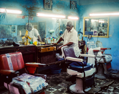 Barber in an old blue barbershop, sample shot on CineStill 800T