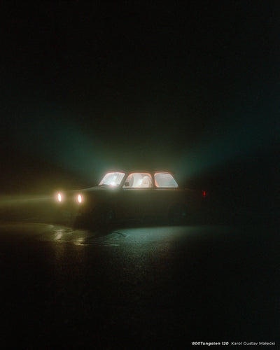 Car with glowing windows in fog at night, sample shot on CineStill 800T