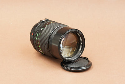 Canon nFD 135mm f/2.8, front three-quarter view with lens cap