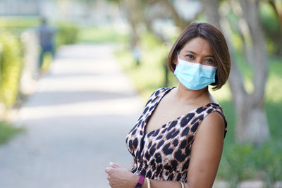 Woman in a face mask on a park path, Canon nFD 85mm f/1.8 sample