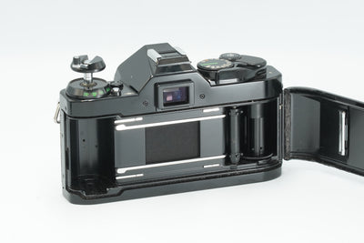 Canon AE-1 Program black with the back open, showing the film chamber