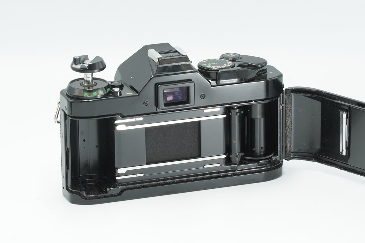 Canon AE-1 Program black with the back open, showing the film chamber