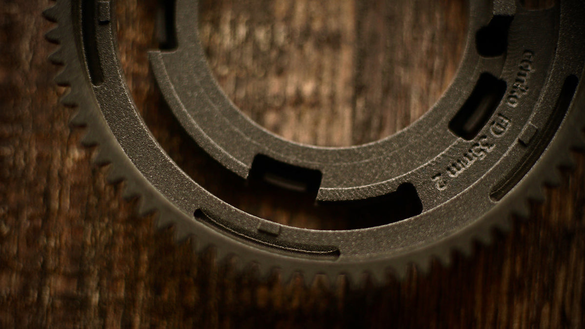 SIMMOD conversion kit gear ring on a wooden surface, close-up