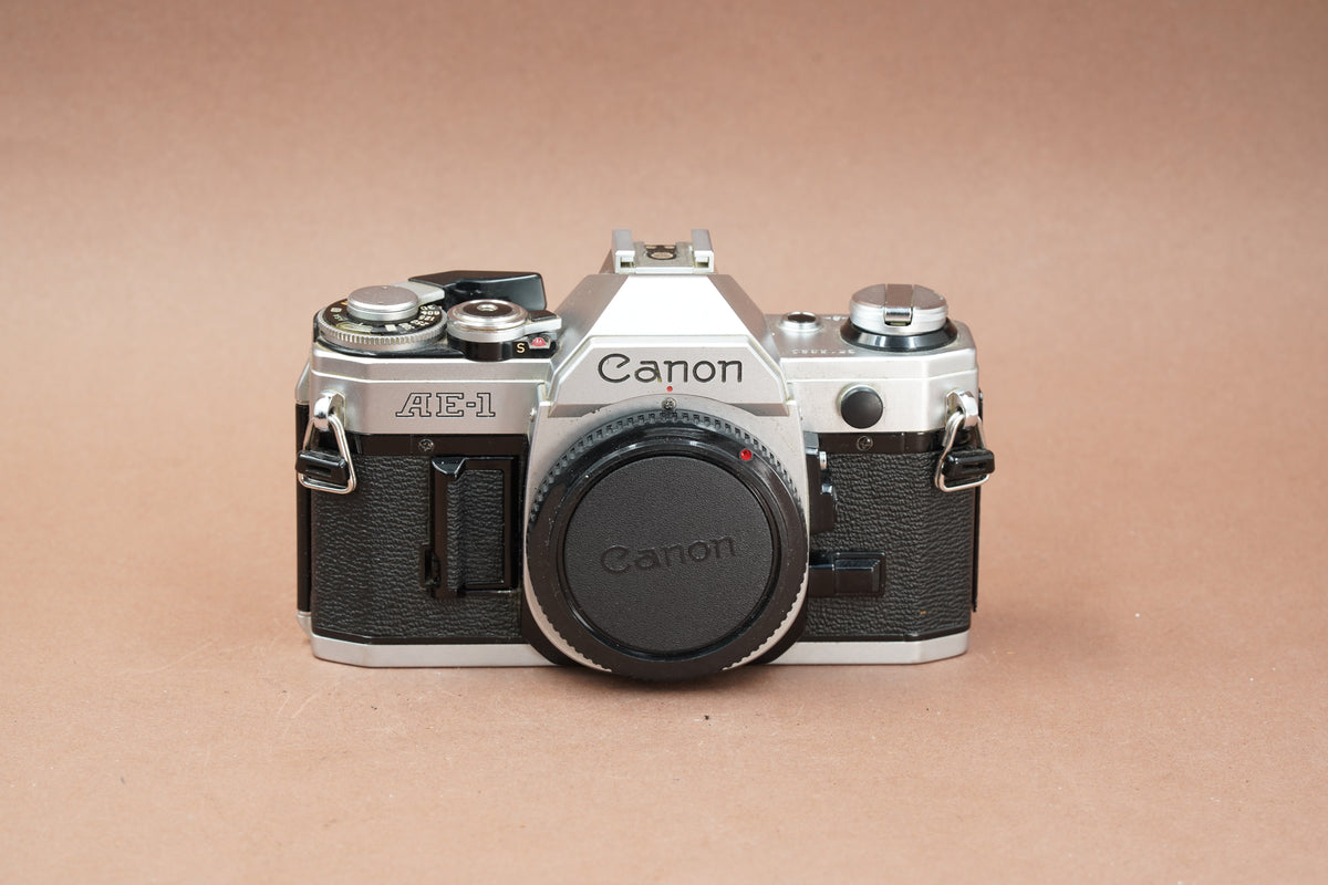Canon AE-1 silver 35mm SLR, front view with body cap