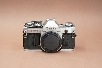 Canon AE-1 silver 35mm SLR, front view with body cap