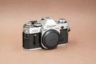 Canon AE-1 35mm SLR film camera in silver and black with body cap