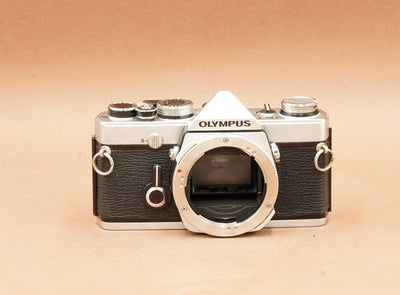 Olympus OM-1 silver camera body without lens, front view