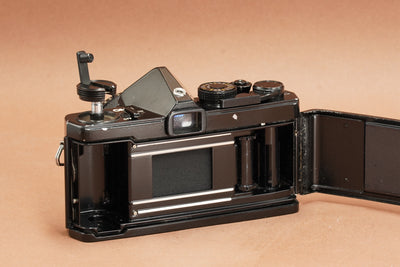 Olympus OM-1 black film camera with the back open, showing the film chamber