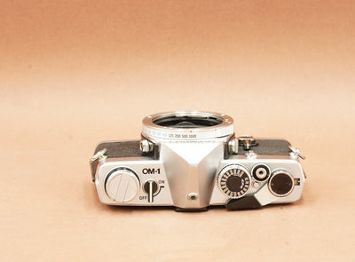 Olympus OM-1 silver, top view with shutter speed ring and film rewind