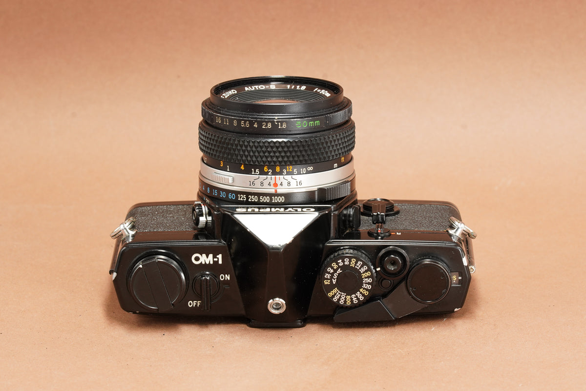 Olympus OM-1 black with Zuiko 50mm f/1.8, top view of the shutter speed dial